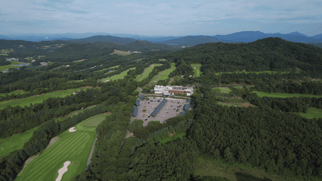 Aerial view of a golf course surrounded by lush forests