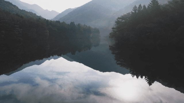 Tranquil lake surrounded by misty mountains