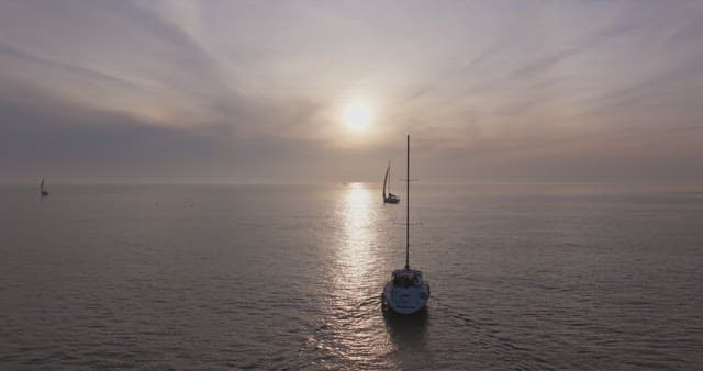 일몰에 잔잔한 바다 위의 요트