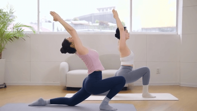 Pilates instructor guiding a student indoors