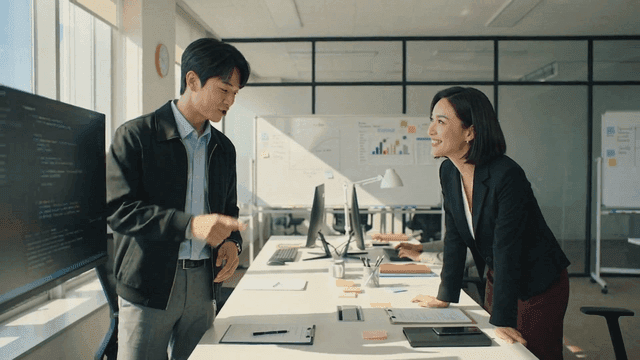 Colleagues discussing work at a desk