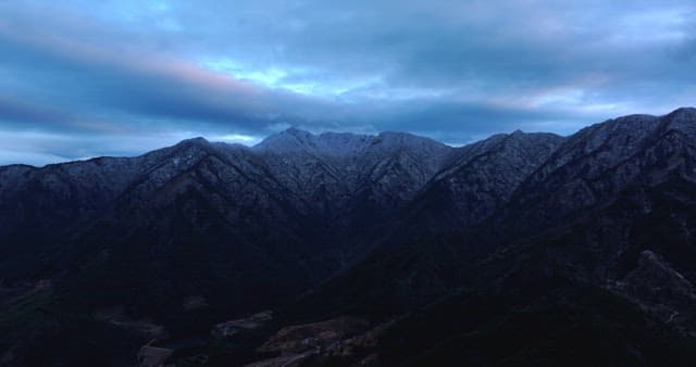 Snow-covered mountains under cloudy skies