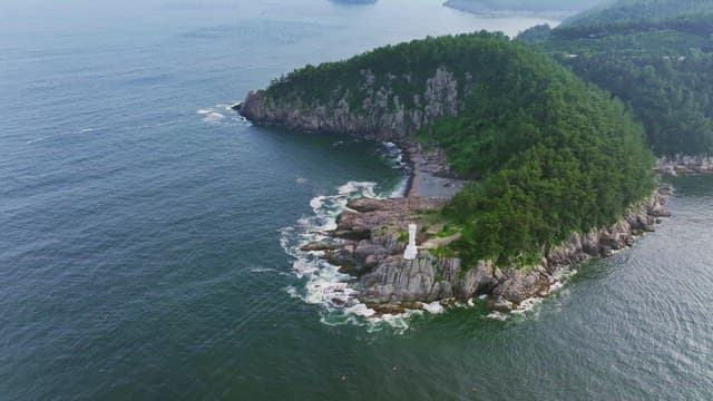 푸른 숲과 등대가 있는 아름다운 섬