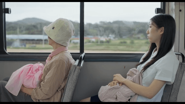Two women sitting on a bus and looking out the window