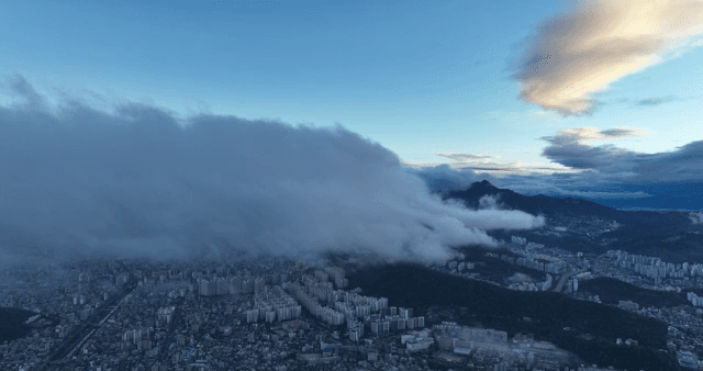 Cityscape with clouds over mountains