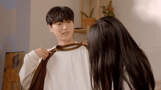 웃으며 같이 옷을 접는 커플