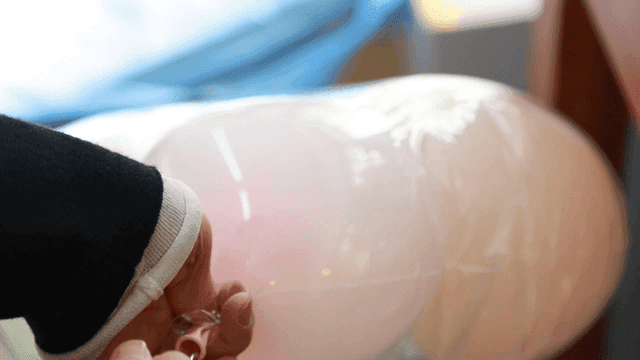 Hand injecting gas into balloon
