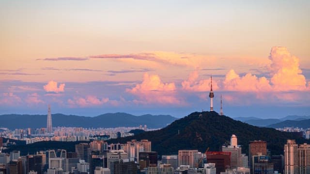 Evening cityscape with mountain skyline and clouds