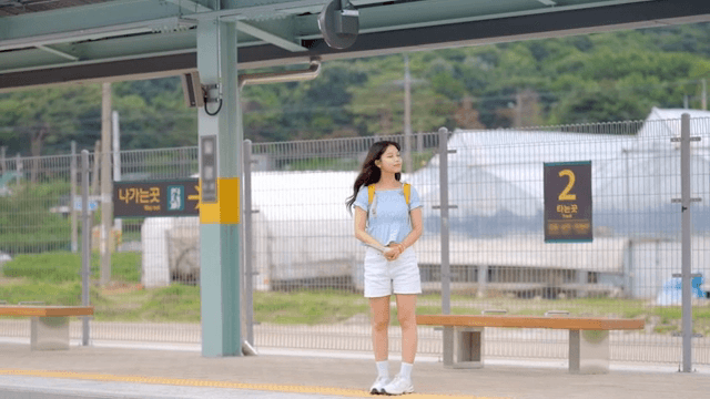 기차역 플랫폼에서 기다리는 여성