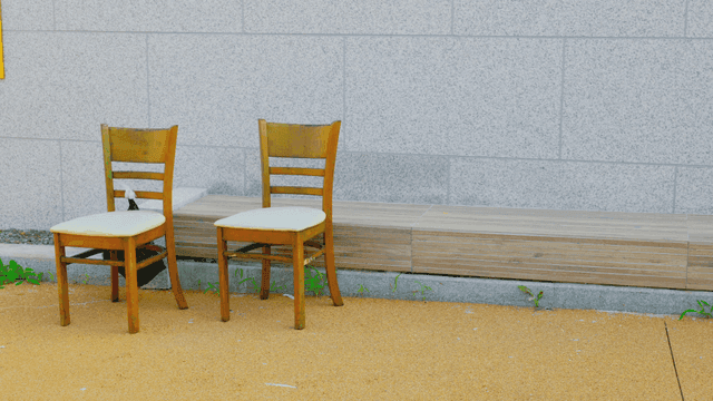 벽 앞에 놓인 두 개의 나무 의자와 긴 벤치
