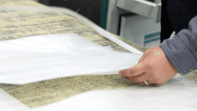 Hands arranging white fabric sheets