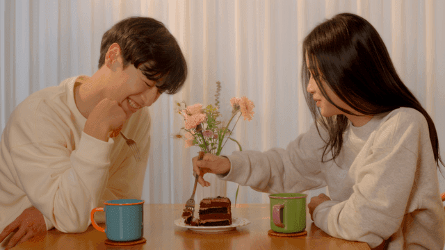 Couple enjoying cake at dining table