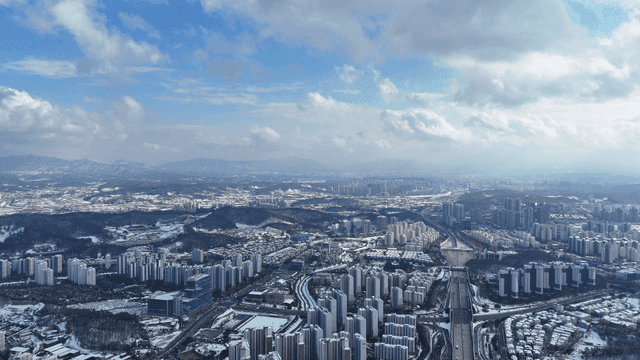 Snow-covered cityscape with distant mountains