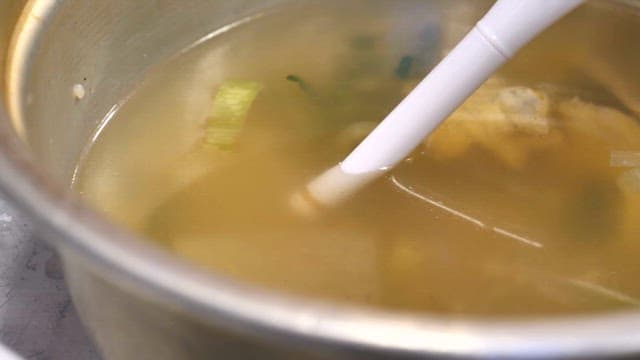 실내에서 측정기로 된장국의 염도를 테스트하는 손