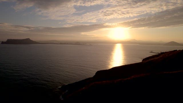 Coastal Sunset with Distant Islands