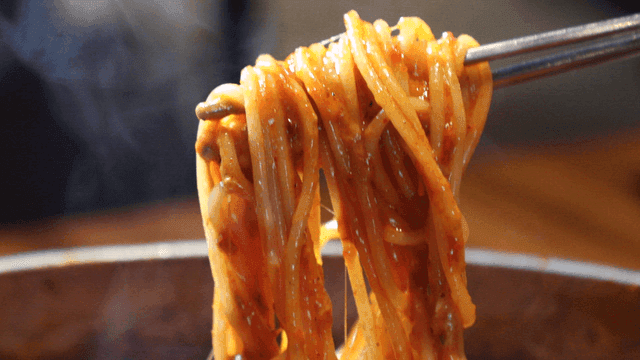 Chopsticks lifting spicy noodles