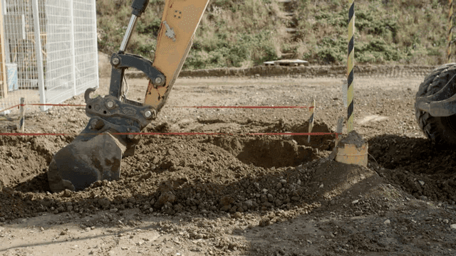 표시된 구역의 땅을 파는 굴삭기