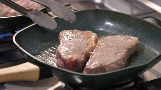 프라이팬에서 요리되는 소고기 스테이크