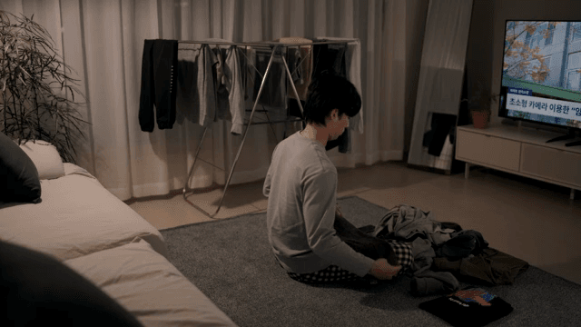 TV를 보며 빨래를 개는 사람