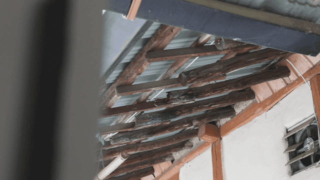 Old rural wooden beams and metal roof structure