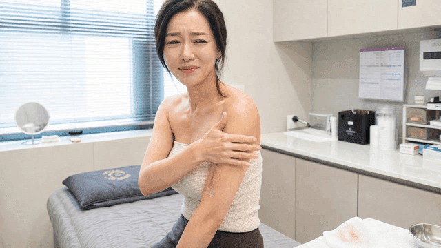 Female patient looking at scar on her arm