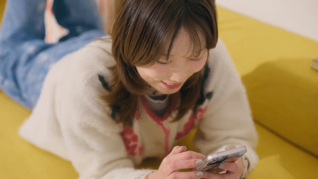 스마트폰을 사용하며 웃고 있는 여성