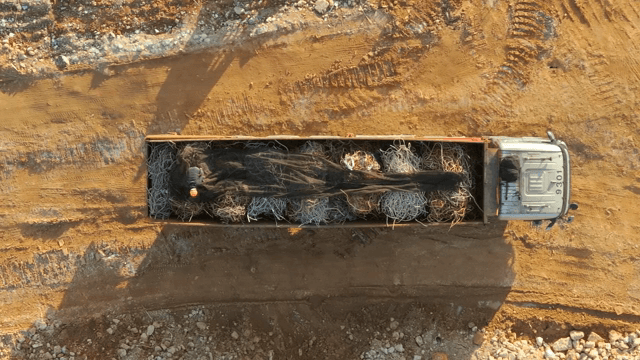 흙길 위 금속 와이어를 실은 트럭