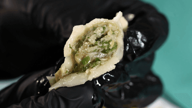 Dumplings with juice oozing out when pressed with gloved hand