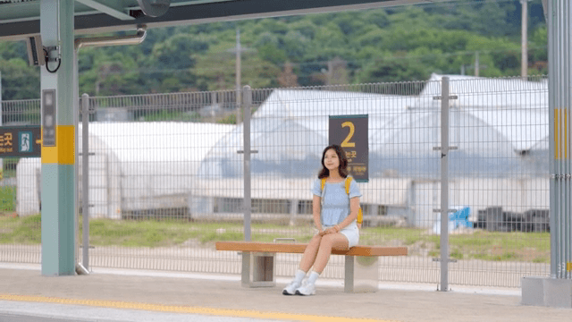 기차역 플랫폼에서 기다리는 여성