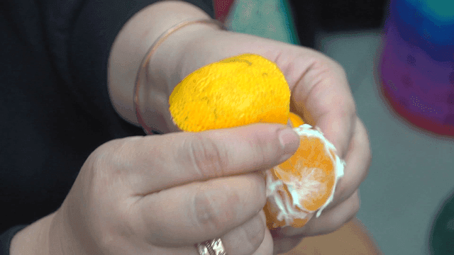 손으로 신선한 귤을 껍질을 벗기는 사람