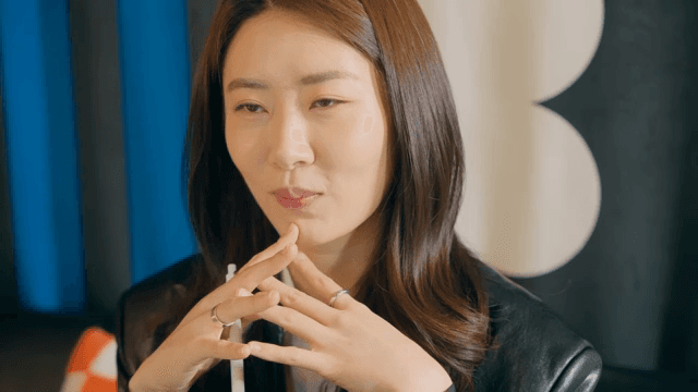 무언가를 바라보며 미소짓는 여성