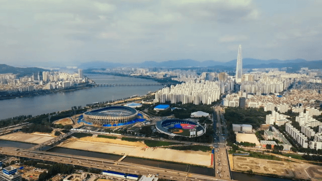 A sprawling cityscape with a river and stadiums