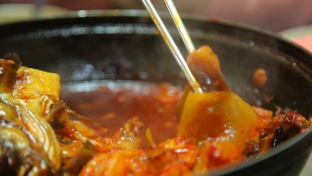 Piece of radish in a spicy braised half-dried pollack boiling in a pot