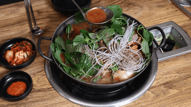 Hot, boiling potato stew with fresh perilla leaves