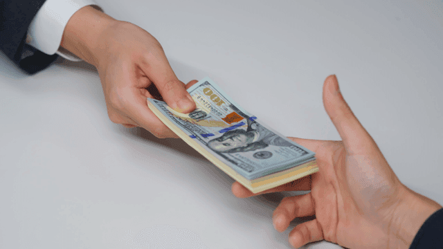 Hands exchanging currency notes