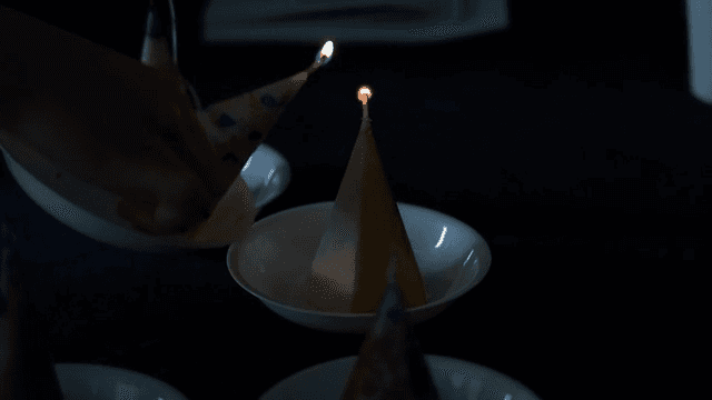 어두운 테이블 위에서 촛불을 켜는 모습
