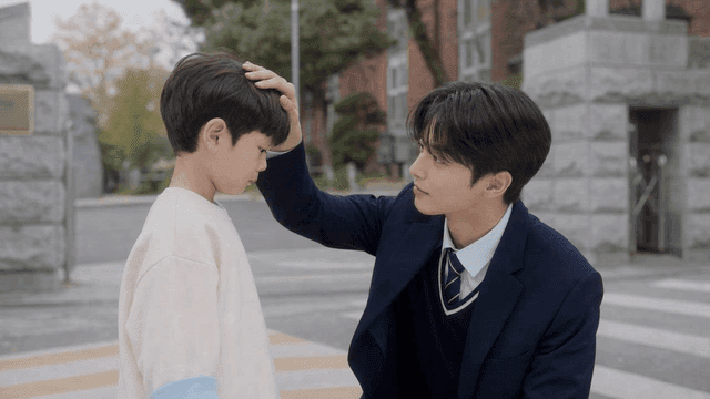 High school student comforting younger sibling in front of school
