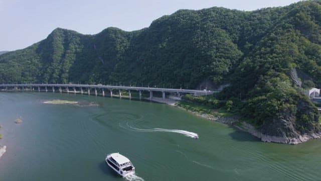 River and Boats under Beautiful Green Mountain Scenery