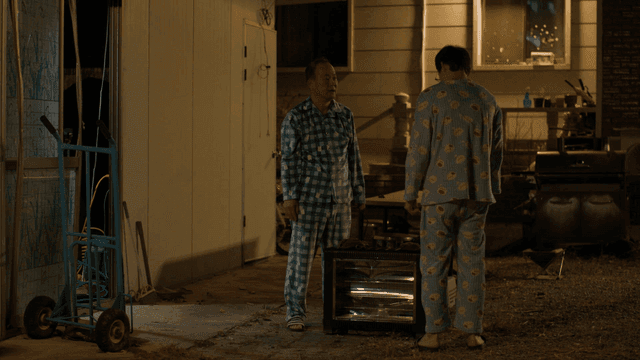 Father and son talking while wiping heater