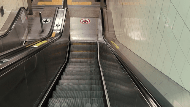 People using an escalator in a subway