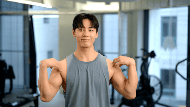 헬스장에서 팔을 돌려 몸을 푸는 젊은 남성