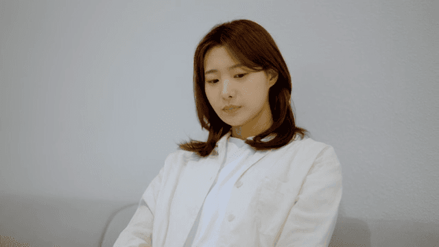 소파에 앉아 초조하게 무언가를 기다리는 여성