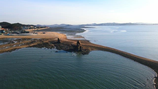 오후에 바닷물이 밀려들어오는 해안 마을의 해변