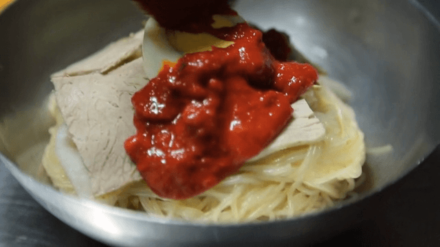 매운 소스를 곁들인 냉면