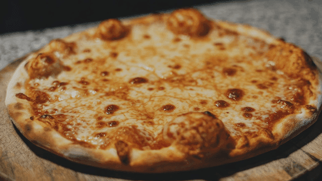 Freshly baked cheese pizza on a wooden board