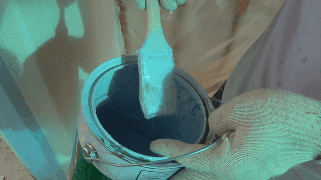 Brush delicately dipped into paint can