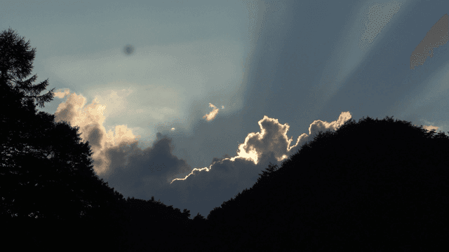 산 너머 구름 사이로 비치는 햇빛 비치는 하늘