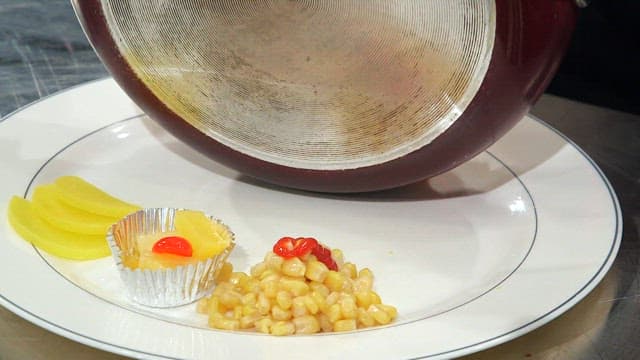 치즈가 들어간 김치볶음밥이 콘샐러드가 있는 접시에 담기는 모습