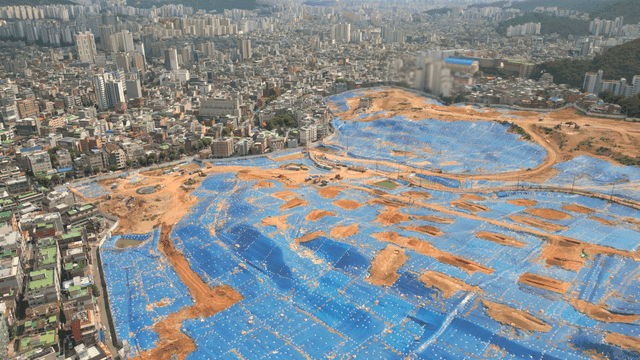 Urban construction site with blue tarps