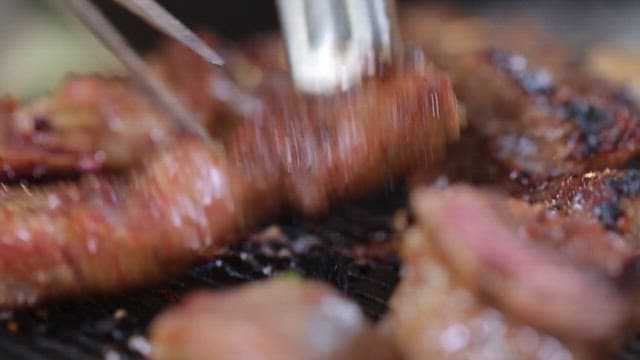 Grilled Meat Close-Up with Tongs